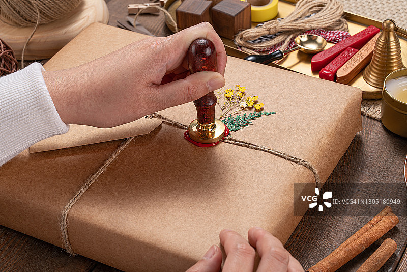 在礼品包装上将蜡印压入封蜡图片素材