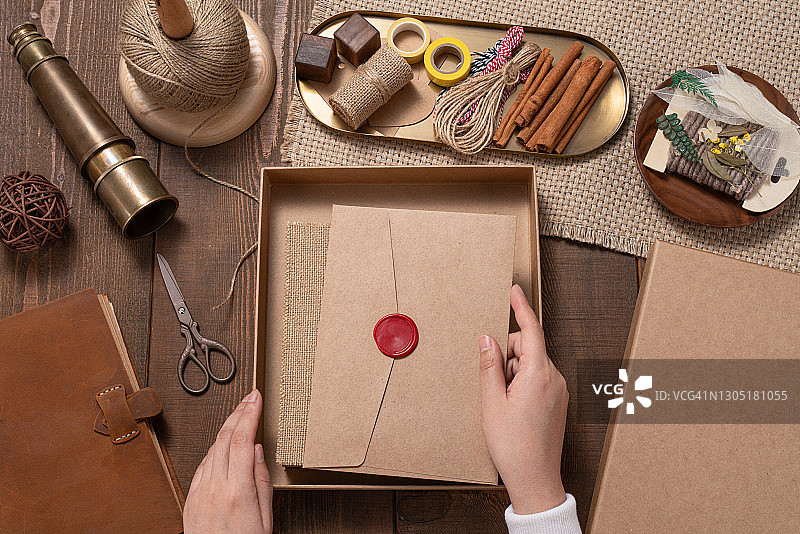 女人将复古信封放入礼品盒图片素材