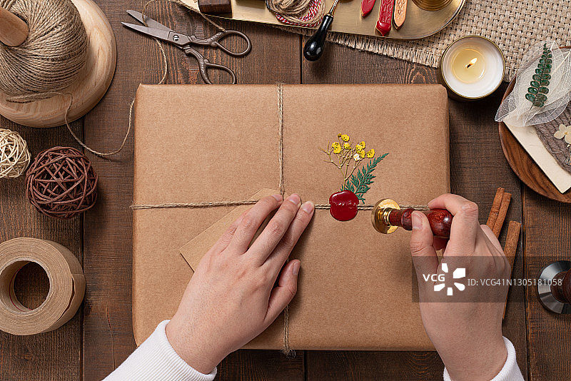 在礼品包装上将蜡印压入封蜡图片素材