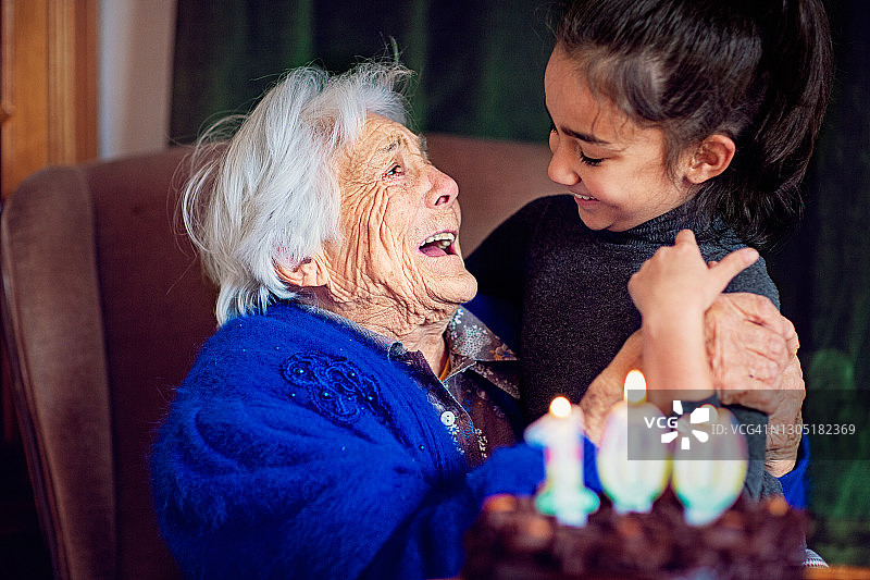 曾祖母在百岁生日时拥抱曾孙女图片素材
