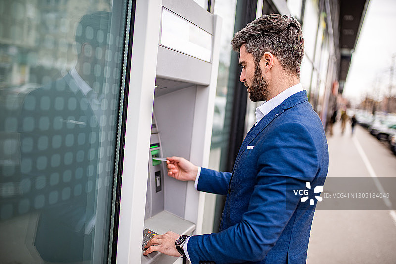 中年商人从ATM取款图片素材