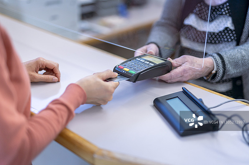 顾客使用非接触式信用卡支付医疗服务费用图片素材