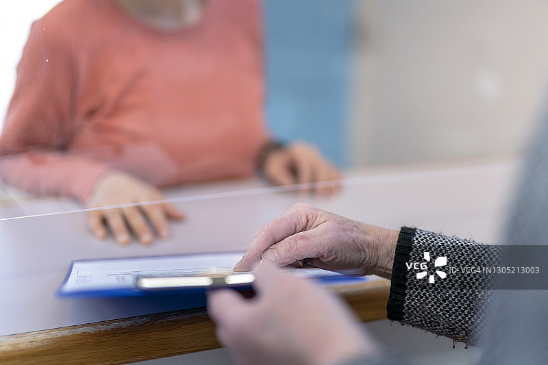 医务人员协助新患者填写登记表图片素材