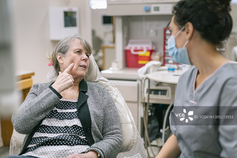 年长的女人因口腔疼痛与牙医交谈图片素材
