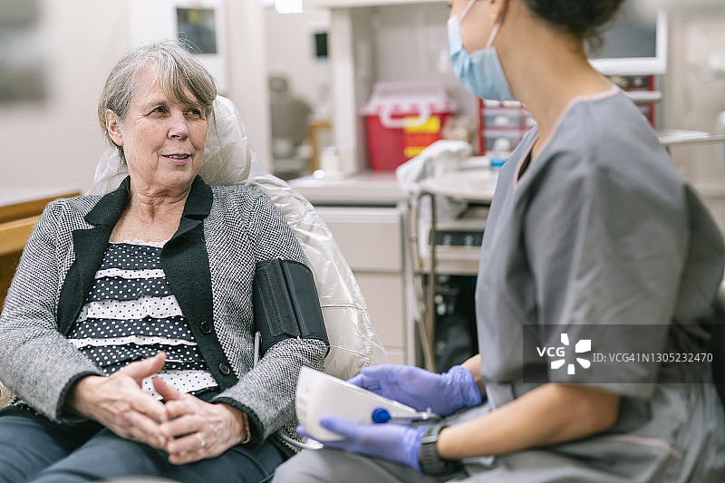 年长的女病人接受体检，测量血压图片素材