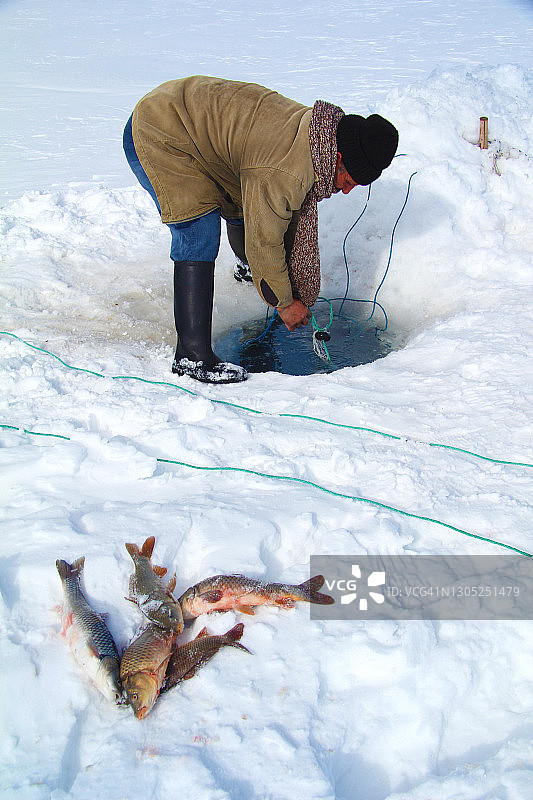 在土耳其卡尔斯，渔民在冰冻的奇尔迪尔湖上钓鱼图片素材