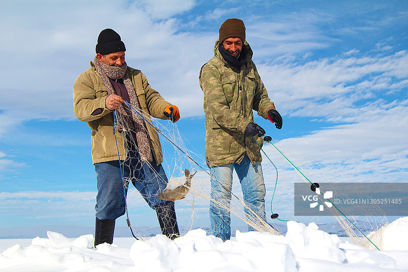 在土耳其卡尔斯，渔民在冰冻的奇尔迪尔湖上钓鱼图片素材