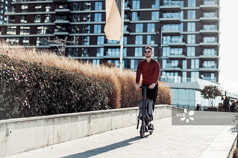 骑电动滑板车的年轻男人图片素材