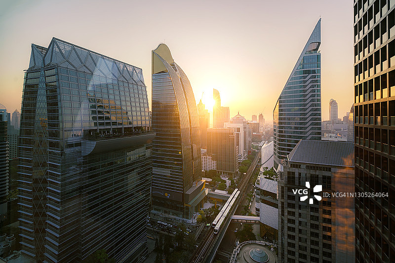 泰国曼谷市摩天大楼、中央商务区和办公室的航拍景色，天空中列车在日落时分经过图片素材