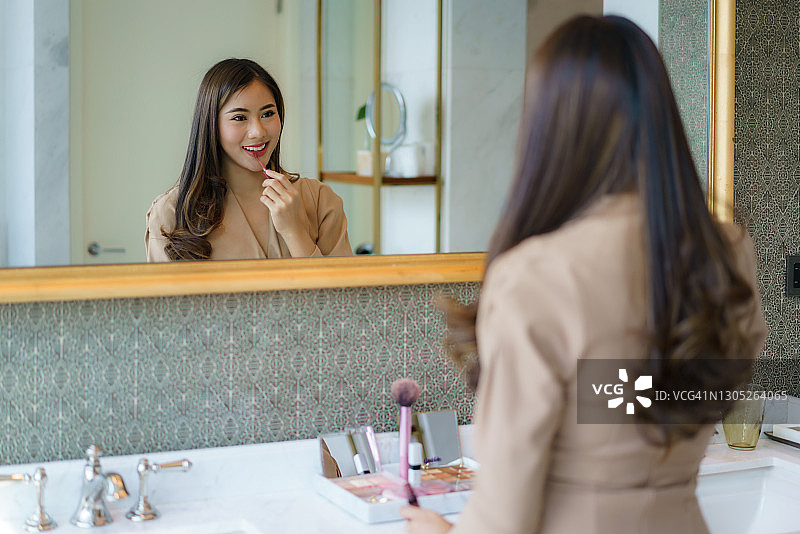 亚洲女性在浴室化妆，准备去上班图片素材