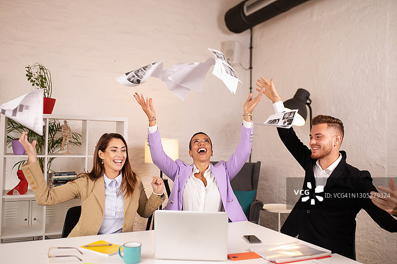 在办公室里扔纸庆祝的商人们图片素材