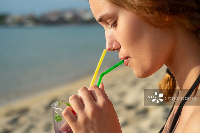 年轻漂亮的女人享受莫吉托图片素材