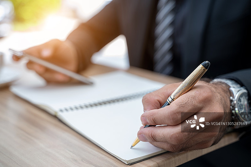 商人用笔记本做笔记的手部特写图片素材