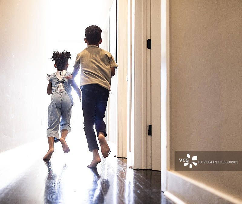 兄妹在家里的走廊上奔跑图片素材