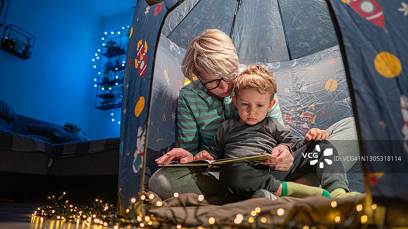 母子在客厅的帐篷里读书图片素材