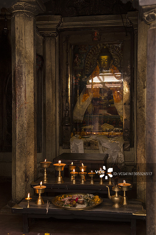 尼泊尔加德满都帕坦拉利特布尔的摩诃菩提寺，佛像前点燃的酥油灯图片素材