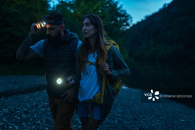 用手电筒走路的两位徒步者图片素材