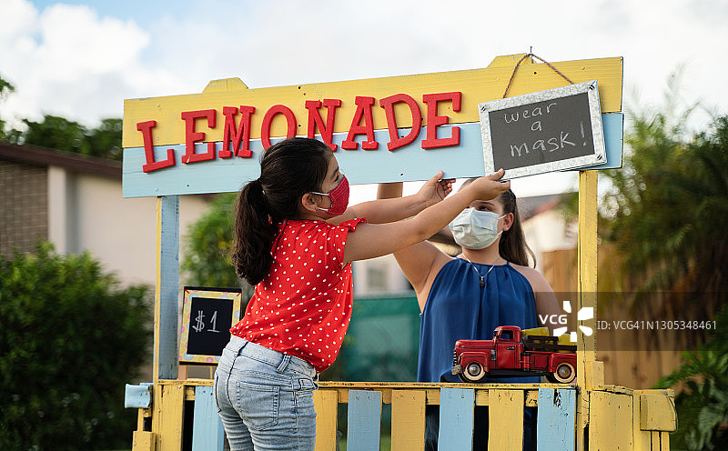 两个女孩在柠檬水摊位上做最后的润色图片素材
