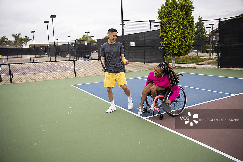 坐在轮椅上的年轻黑人残疾妇女与朋友一起玩匹克球图片素材