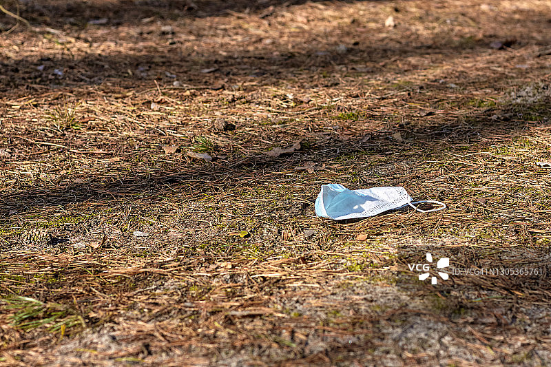森林中被丢弃的防护口罩图片素材