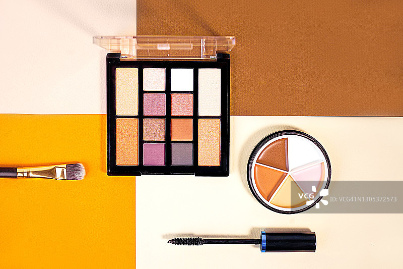 柔和的橙棕色和米色背景上的各种化妆品概念图片素材