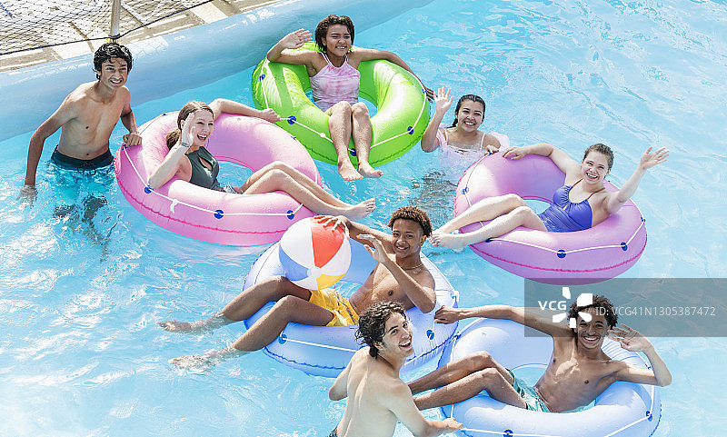 在水上乐园的漂流河中玩耍的青少年图片素材