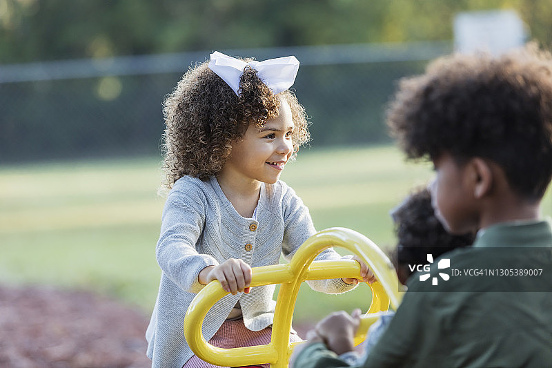 混血小女孩玩跷跷板图片素材