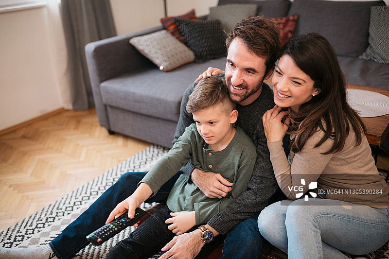 快乐的白人家庭在家看电视图片素材