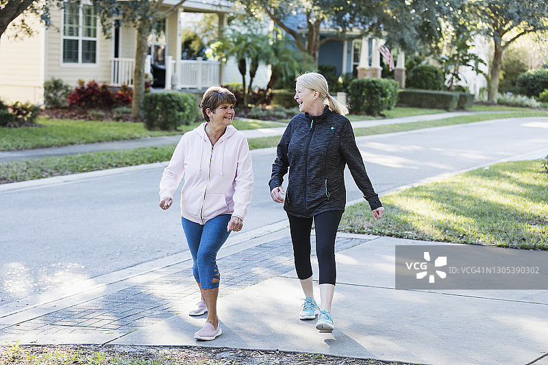 两位老年妇女在车道上锻炼时聊天图片素材