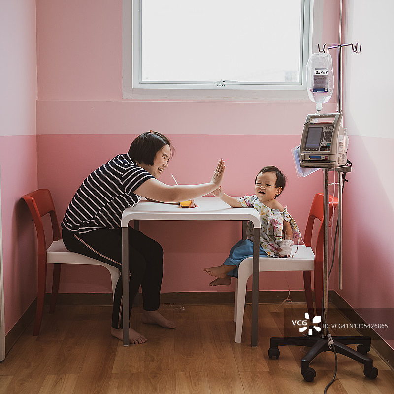 在医院里，母亲和儿子击掌图片素材