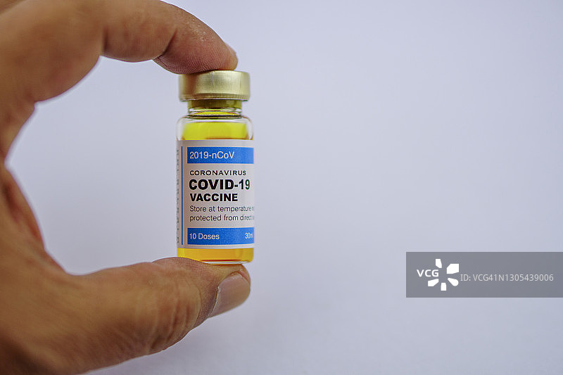 手持新冠疫苗瓶的手部特写图片素材