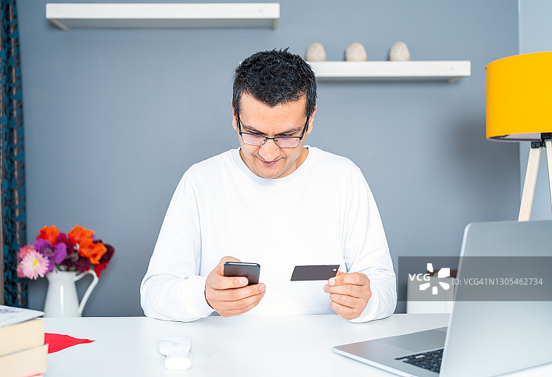 男人使用信用卡进行在线支付和购物图片素材