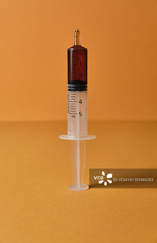 黄色背景上的糖浆注射器图片素材