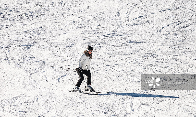 在冬日里从山上滑下的滑雪女人图片素材
