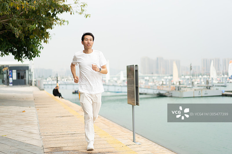 亚洲男人独自在海滩跑步图片素材
