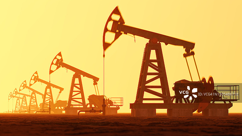 日落时分天空下的油泵轮廓图片素材