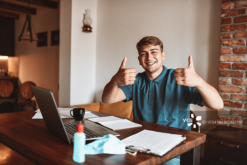 微笑的男人在家工作并分享积极的氛围图片素材
