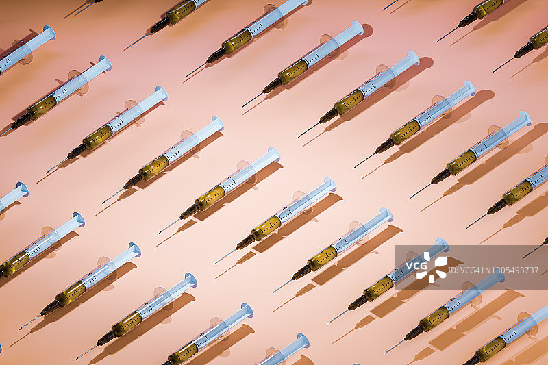 浅棕色背景上成排排列的多种疫苗注射器图片素材