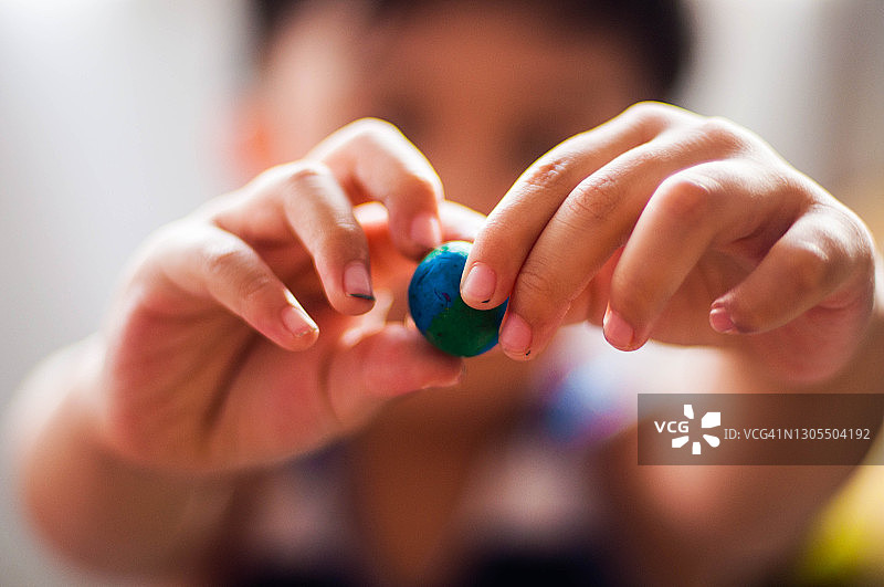 正在玩橡皮泥的东南亚男童图片素材