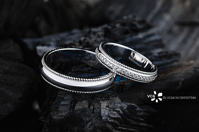 木质背景上的时尚银色结婚戒指图片素材