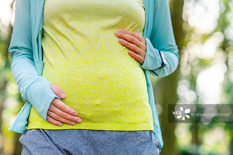 在自然界中穿着运动服的孕妇肖像图片素材