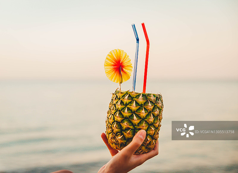女人手持菠萝鸡尾酒图片素材