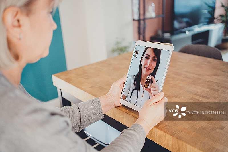 中年妇女与家庭医生进行视频会议图片素材