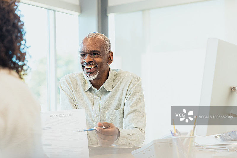 中年男性贷款专员协助客户办理贷款申请图片素材