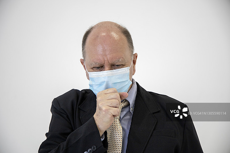 健康问题：戴绿色口罩的商人咳嗽图片素材