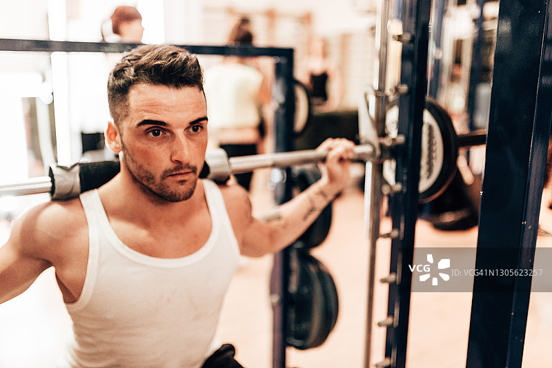 男人在健身房做深蹲图片素材