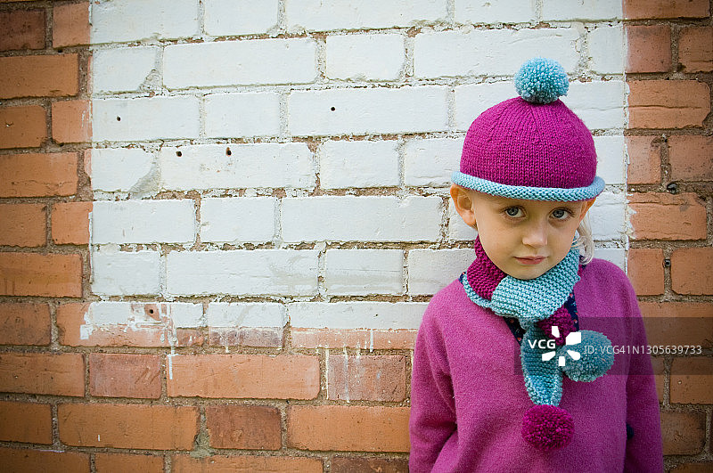 戴着粉色绒线帽的快乐小女孩图片素材