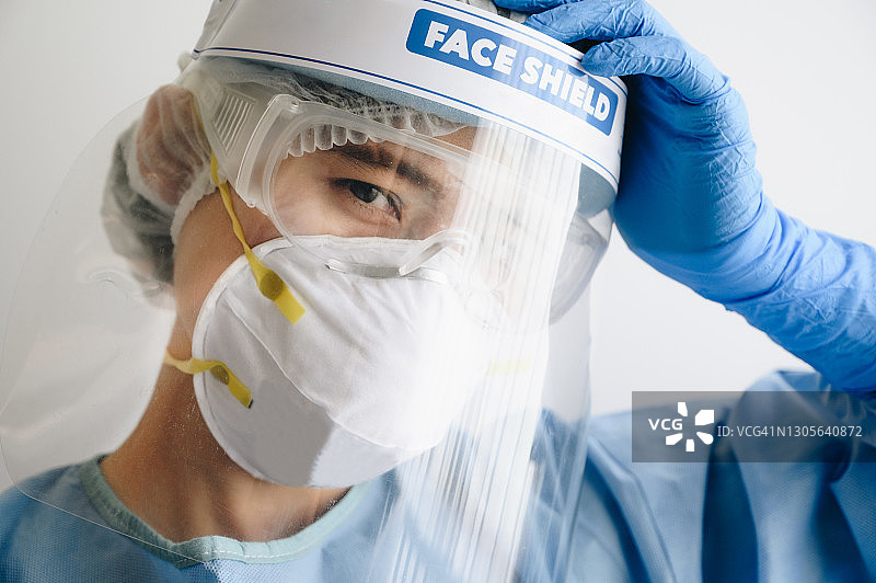 疫情期间在医院长时间工作导致头痛和疲惫的女医护人员图片素材