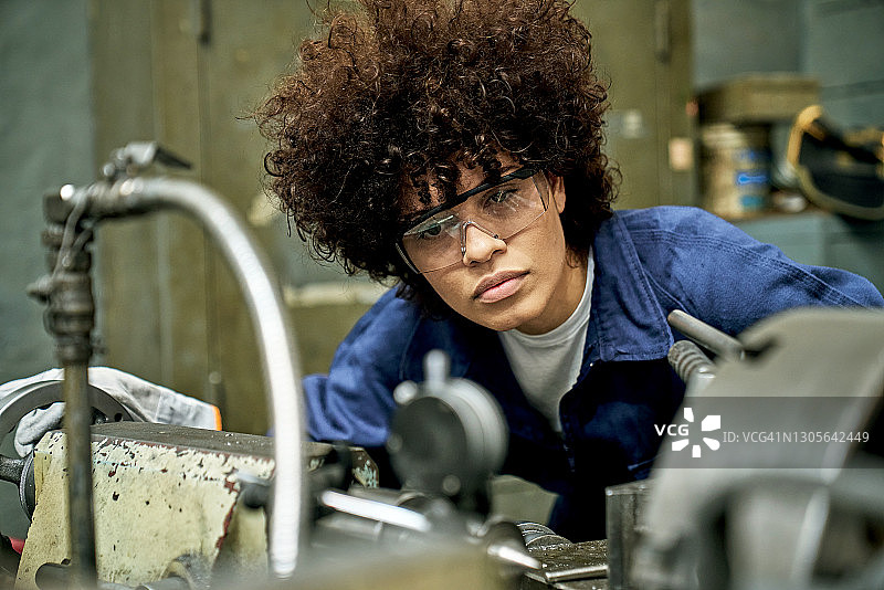 女金属工操作机器的抓拍肖像图片素材