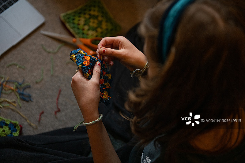 坐在地板上钩针的少女图片素材